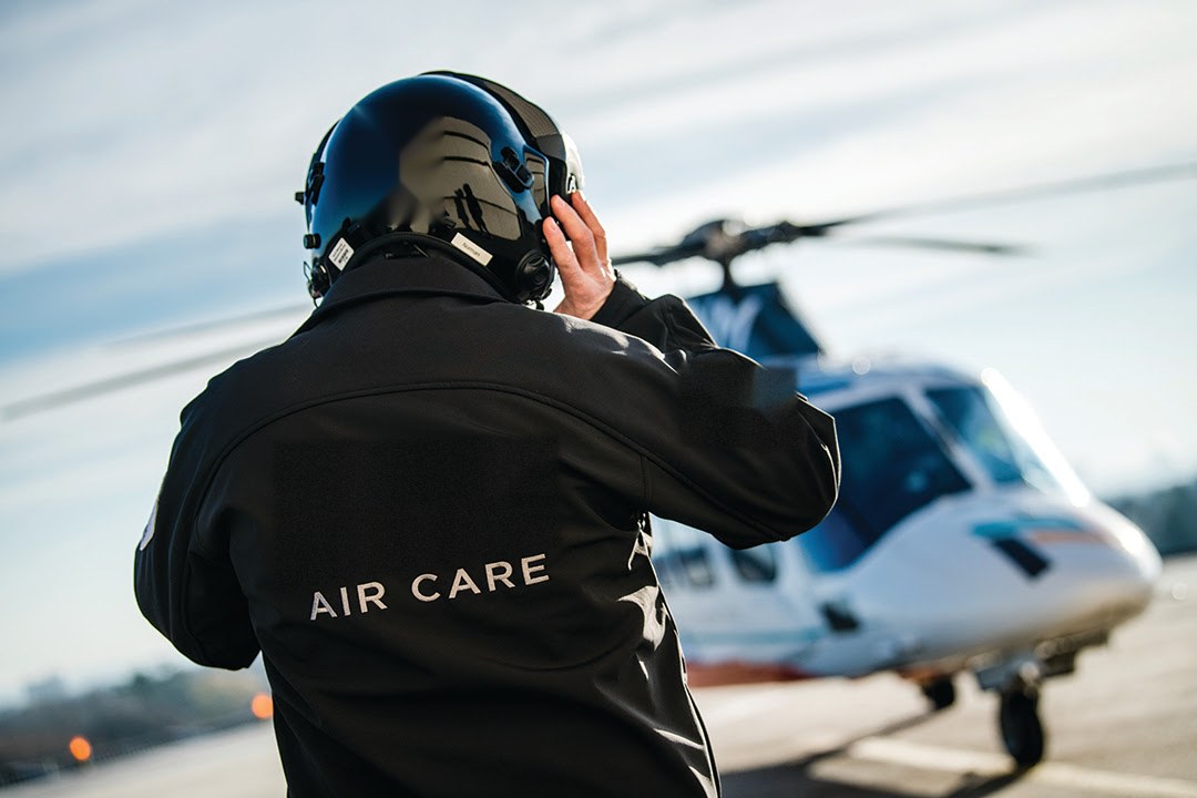 Air care crew member walking toward a medical helicopter