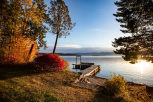 Wooden dock extending from an autumn shoreline into a calm lake.