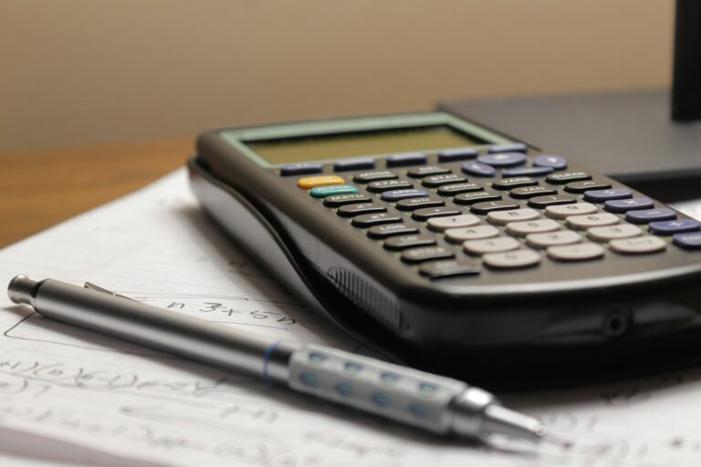 Calculator and pen resting on paperwork.