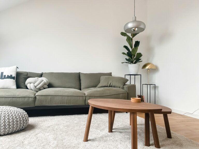 Gray sofa, wooden coffee table, lamp, and houseplant in a living room.