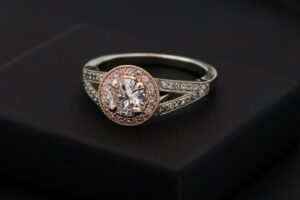 Gemstone ring displayed against dark fabric.